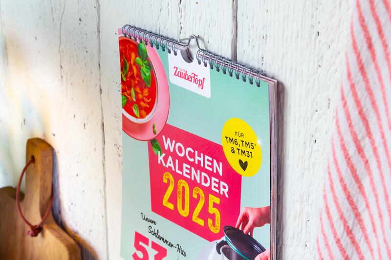 Der mein ZauberTopf Wandkalender in Nahaufnahme hängt an einer weißen Holzwand