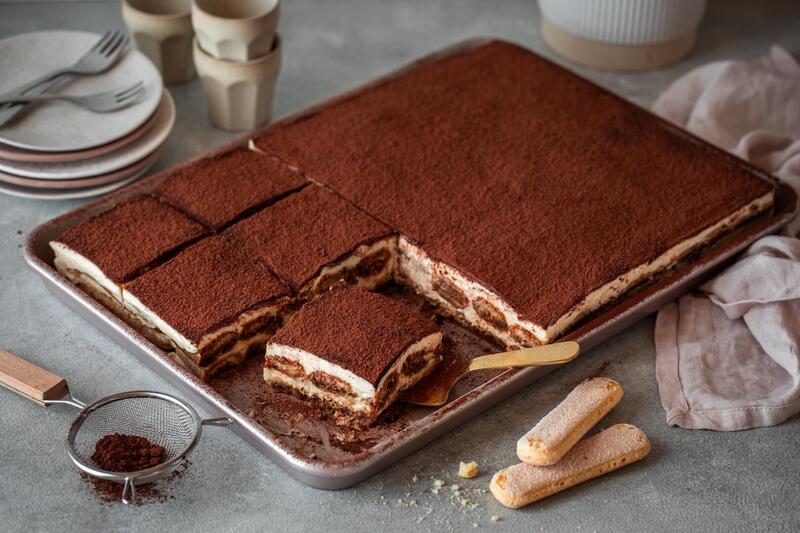 Tiramisu auf einem großen Blech, angeschnitten