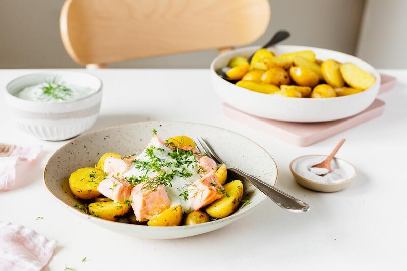 Kartoffeln und Lachs mit Quark und Dill auf einem hellen Teller