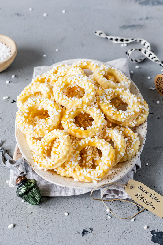 Saure-Sahne-Plätzchen mit Hagelzucker auf einem Teller.