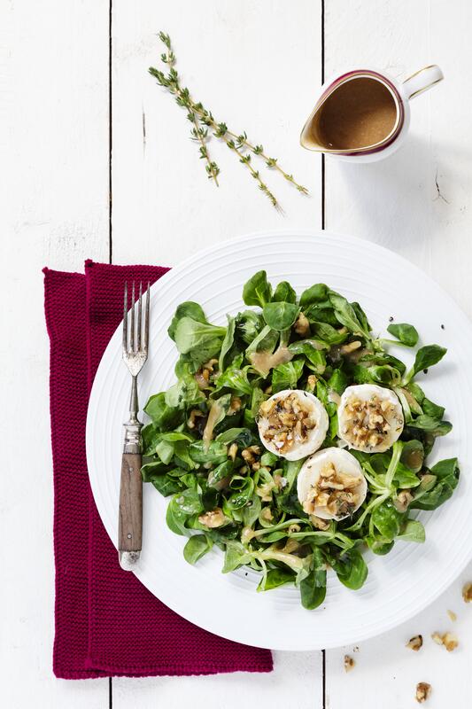 Weißer Teller mit Ziegenkäse auf Feldsalat