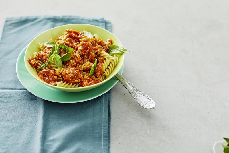 Hellgrüner tiefer Teller mit Fusili und Tofu-Bolognese